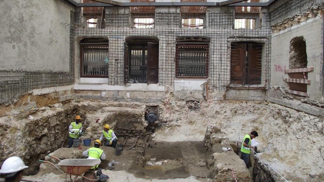 Pessoas com coletes refletores verdes trabalham numa escavação arqueológica no interior da antiga igreja de S. Julião