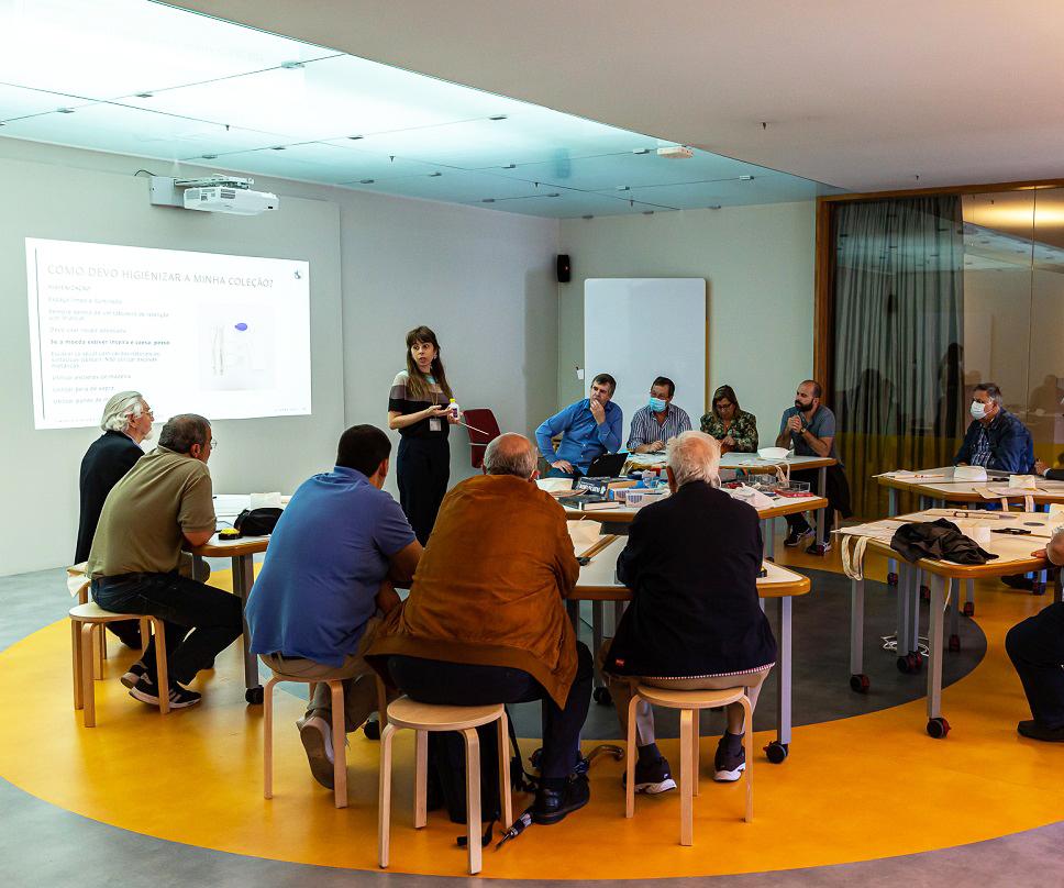 Pessoas sentadas à volta de uma mesa participam  em workshop